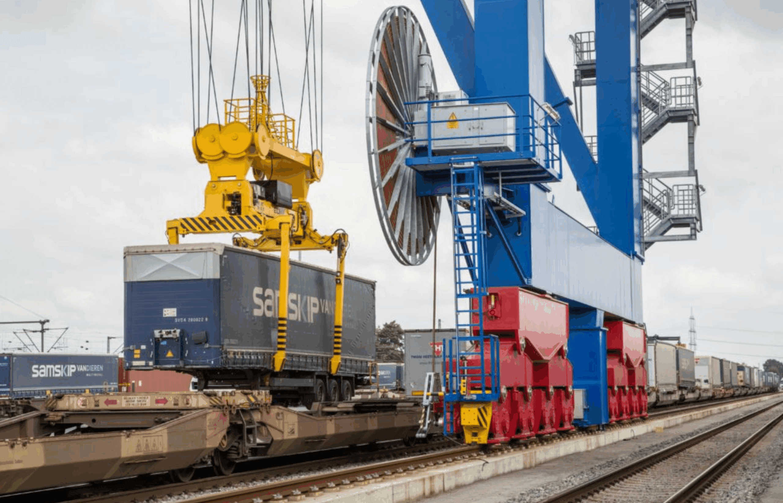 un camion centinato sollevato in un terminal ferroviario
